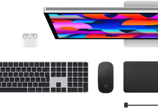 لقطة علوية تعرض مجموعة من اكسسوارات Mac‏: شاشة Studio&nbsp;Display، ولوحة مفاتيح ماجيك، وماجيك ماوس، ولوحة تعقب ماجيك، وAirPods‏، وكابل شحن MagSafe‏