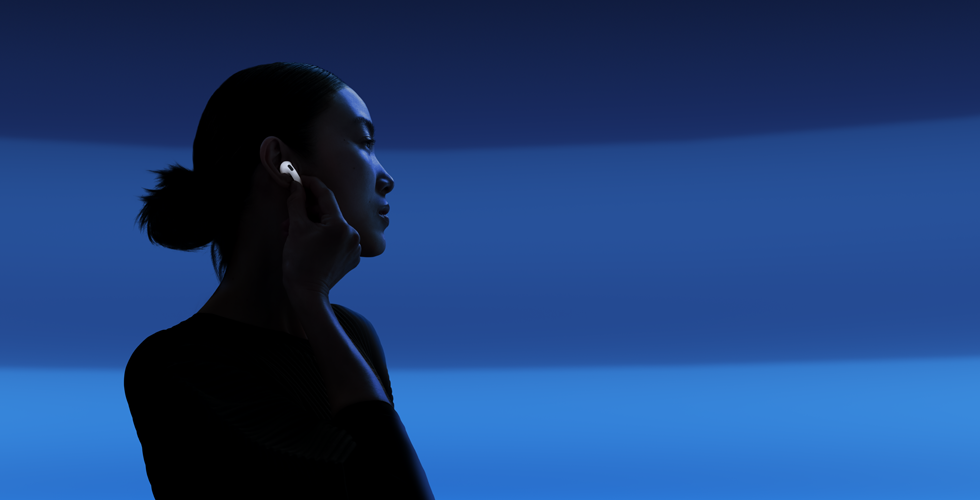 A person with their thumb and pointer finger holding the stem of their AirPods 5 to change listening modes