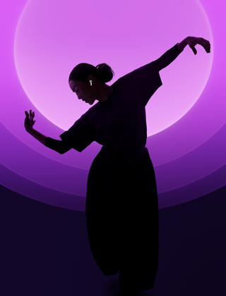 A person dancing while wearing AirPods 5, multi-color background