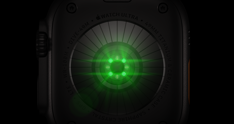 الجهة الخلفية من Apple Watch Ultra 4، إطار تيتانيوم، لون أسود، مستشعرات دائرية متعددة بأضواء LED خضراء متوهجة